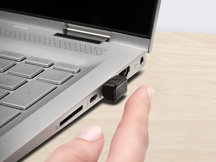 Closeup of a person using a Kensington VeriMark fingerprint key with a laptop