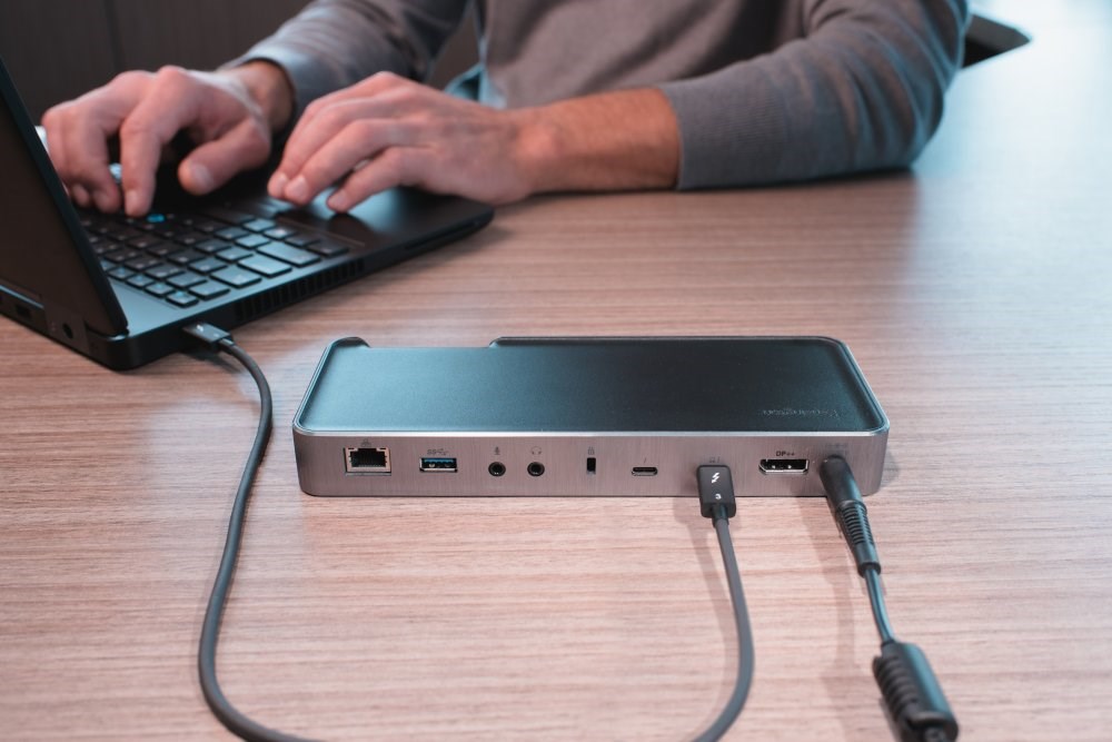 A person using a laptop connected to a docking station 