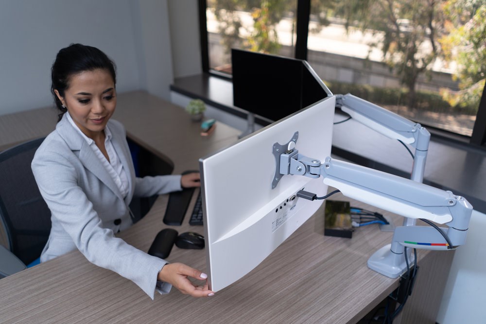 Woman using a Kensington monitor arm for two monitors