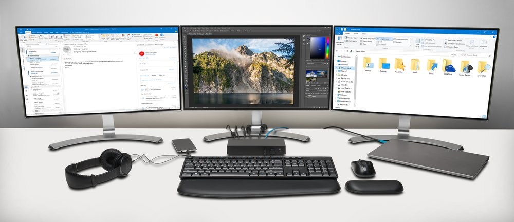 A triple monitor setup and laptop connected to a docking station