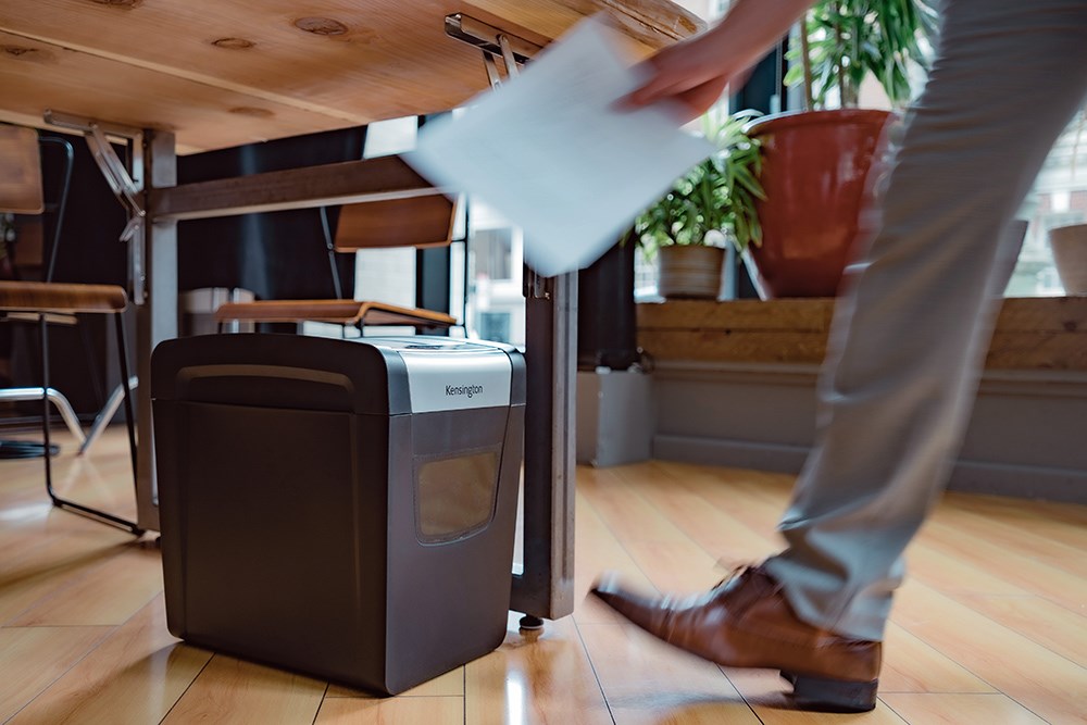 Person placing document into Kensington shredder