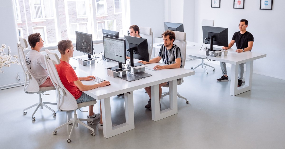 Several people working at seperate computer desk stations