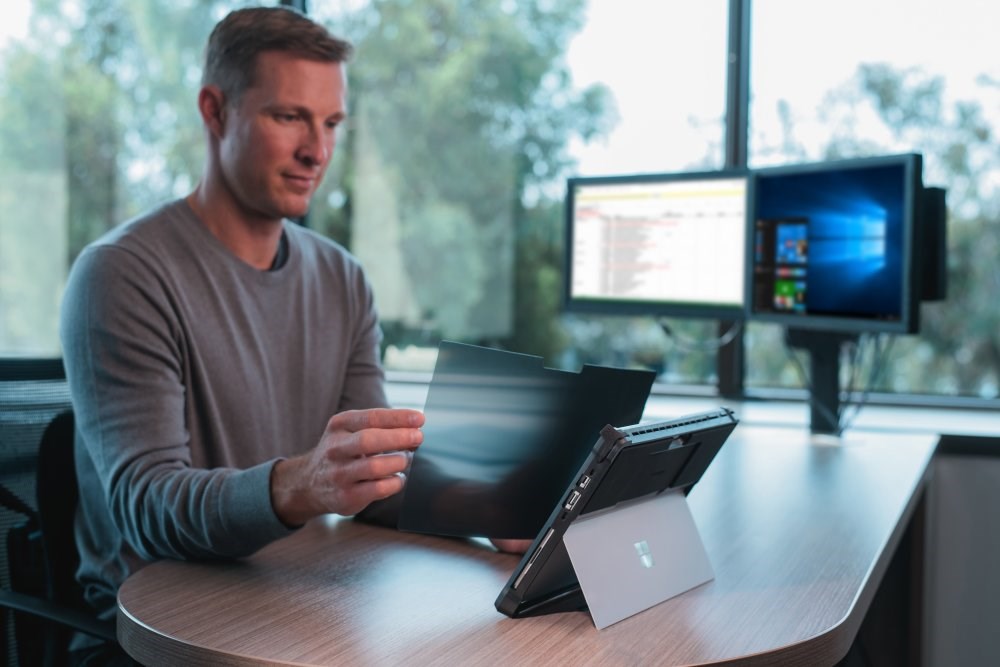 Man placing a privacy screen filter onto a tablet screen