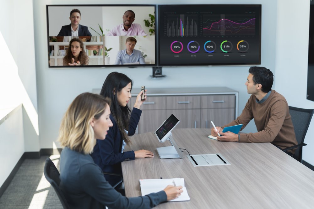 A woman gives a presentation to employees from a Microsoft Surface tablet