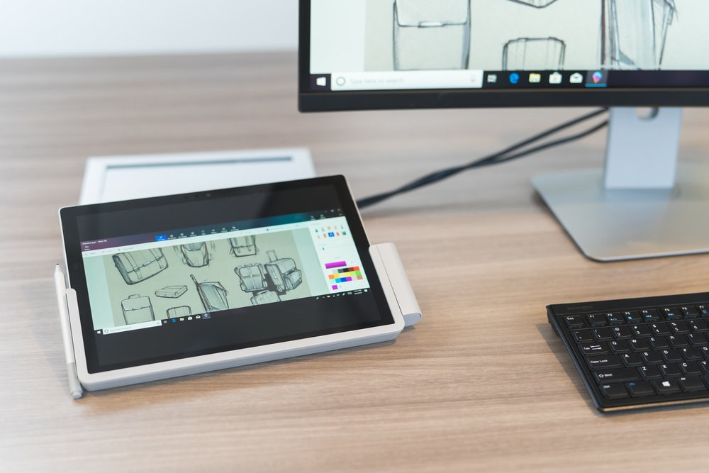 A Microsoft Surface tablet on a desk in a docking station 