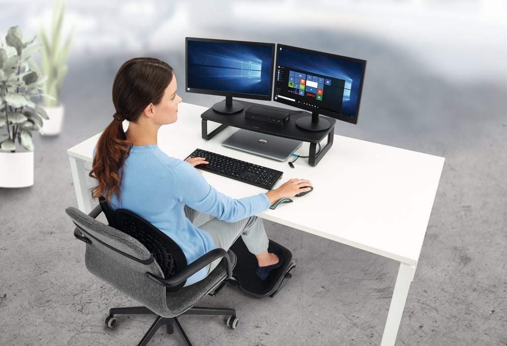 Woman using a SmartFit® Conform™ Back Rest while sitting and using a desktop computer 