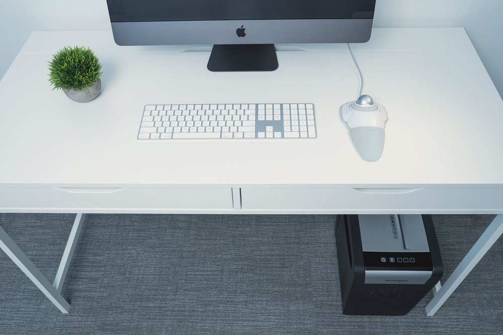 iMac desktop setup with Kensington orbit trackball mouse and a Kensington paper shredder underneath the desk