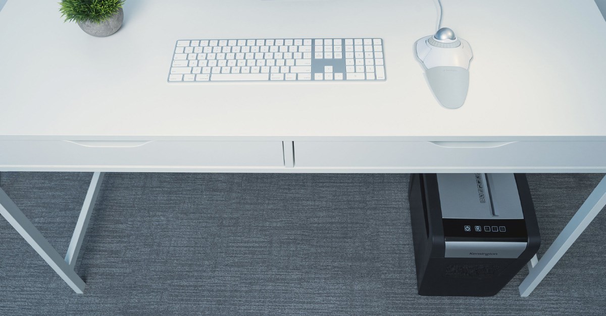 Kensington trackball and keyboard on desk and a Kensington paper shedder underneath