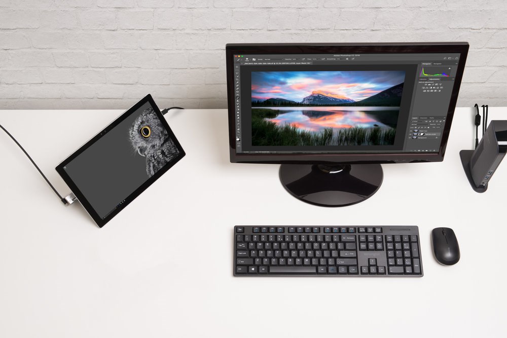 A desktop computer and a tablet sitting next to it with a lock attached