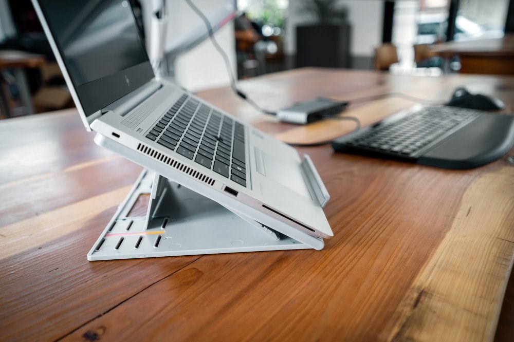 A laptop on a Kensington laptop riser connected to a docking station 