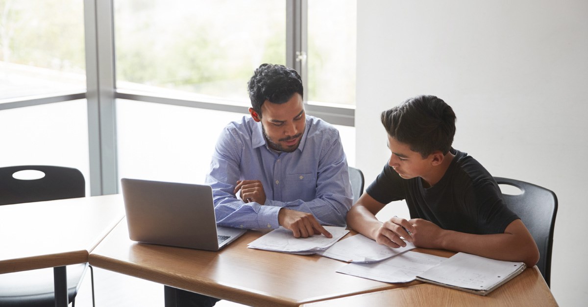 Teacher helping student with school work