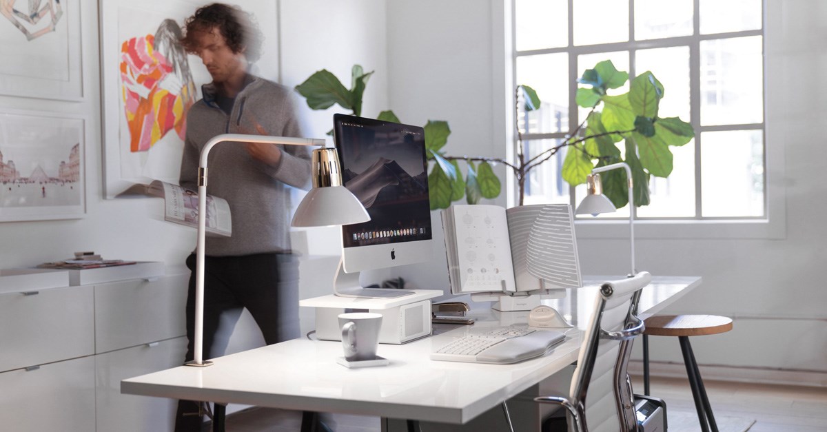 Man walking past a home office desktop setup