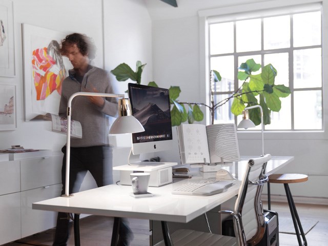 Man walking past his work from home desk