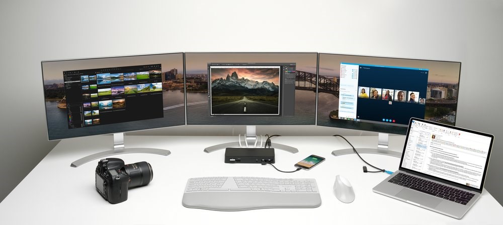 A triple monitor setup and laptop connected to a docking station