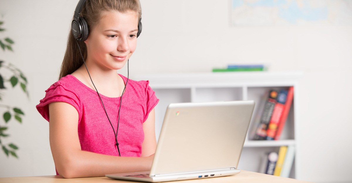 Child wearing headphones and looking at a laptop screen