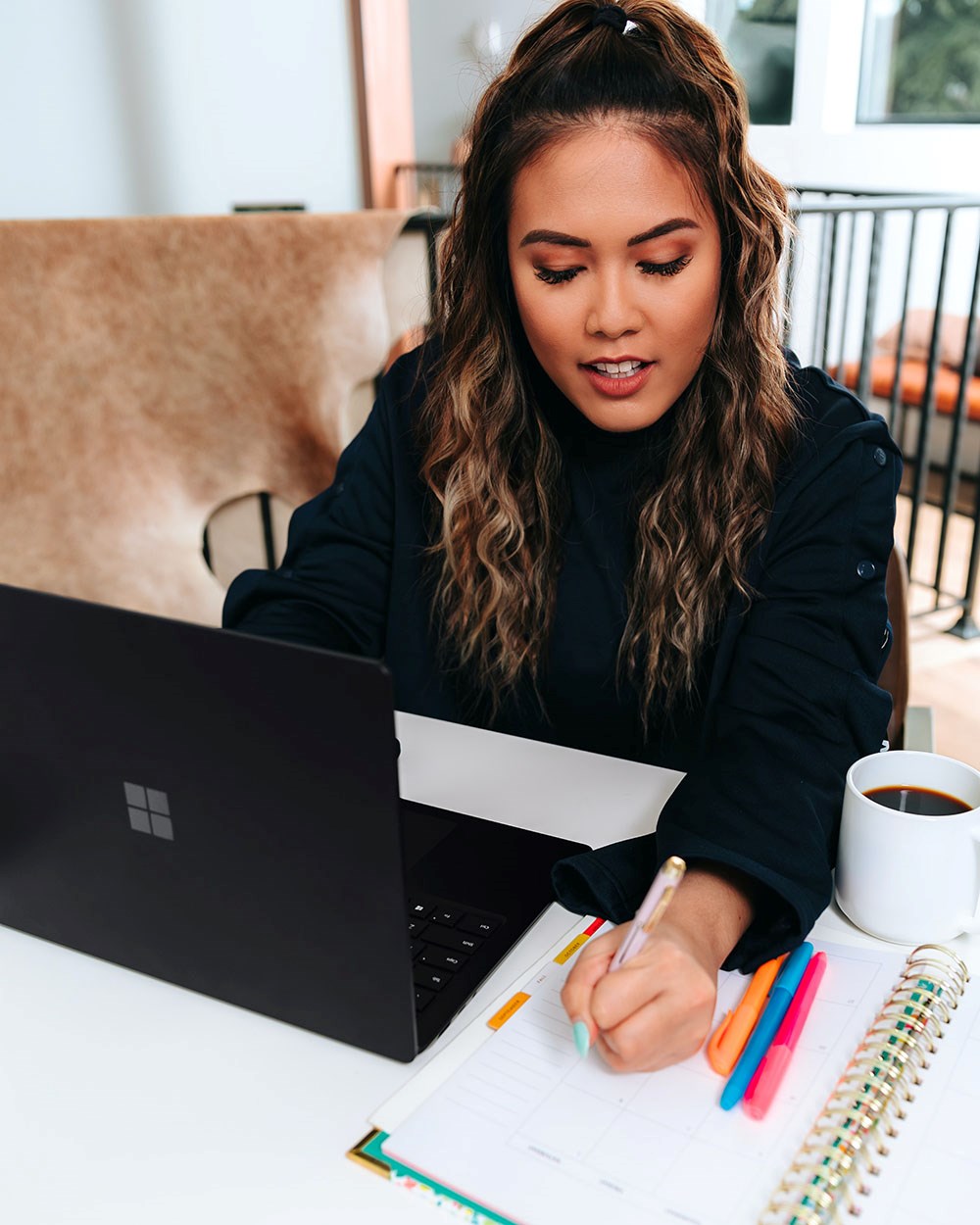 Woman in front of computer writing on a calednar