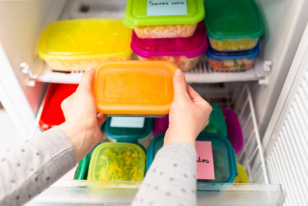 Person taking out a food storage container from the refrigerator 