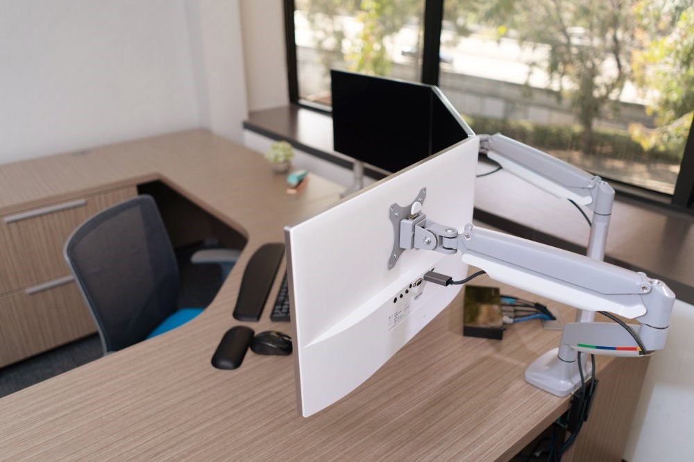 Office setup with computer monitors connected to Kensington monitor arms