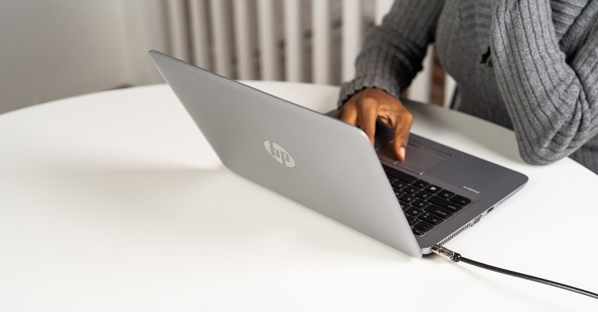 Person using a laptop connected to a laptop security lock