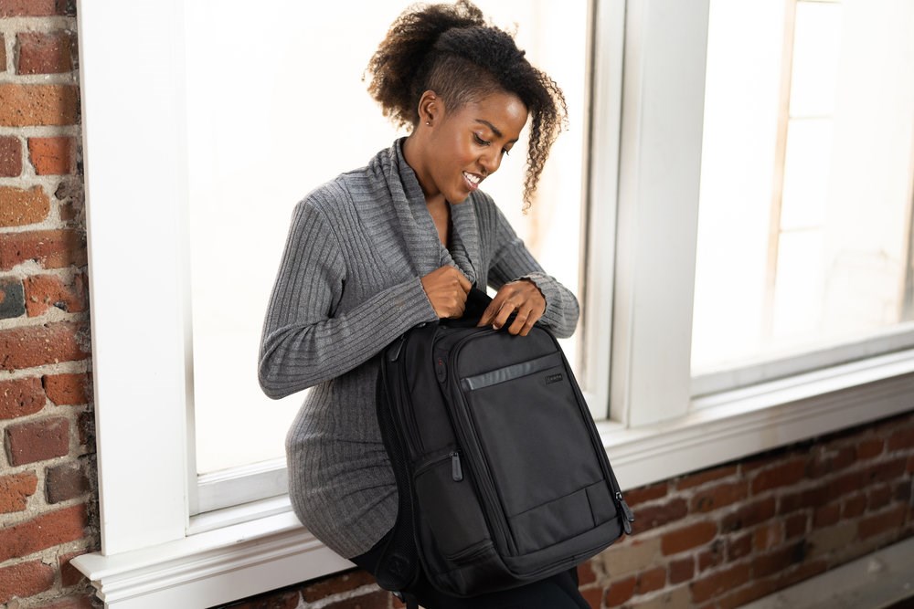 Woman opening a Kensington laptop backpack