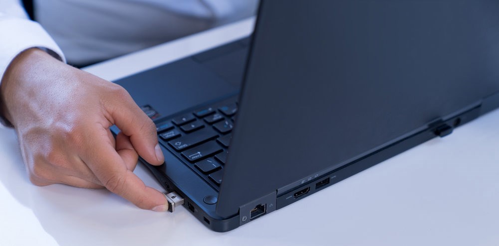 Person using a fingerprint scanner connected to a laptop