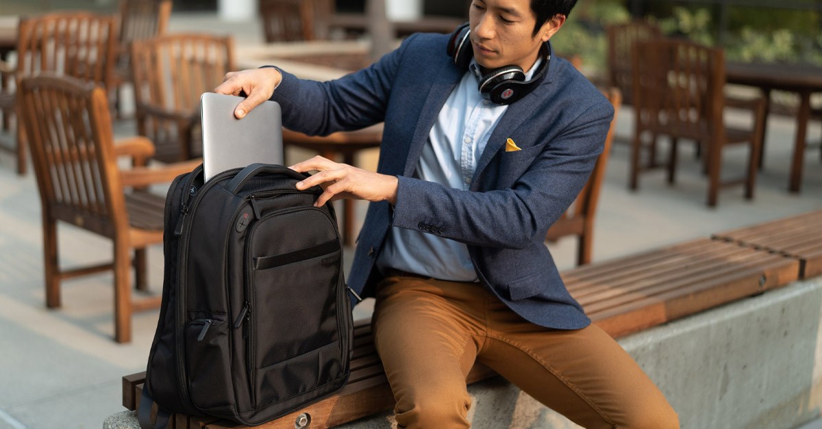 Man putting laptop into backpack