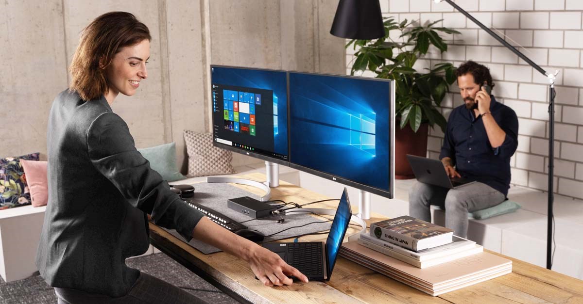 Woman standing at desk with Kensington products