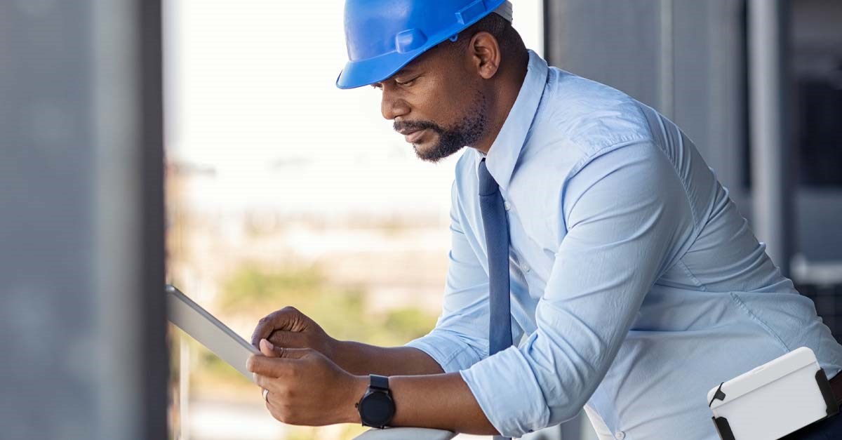 Man in hard hat looking at tablet