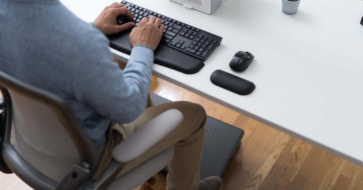Man sitting at desk with Kensington ergonomic products