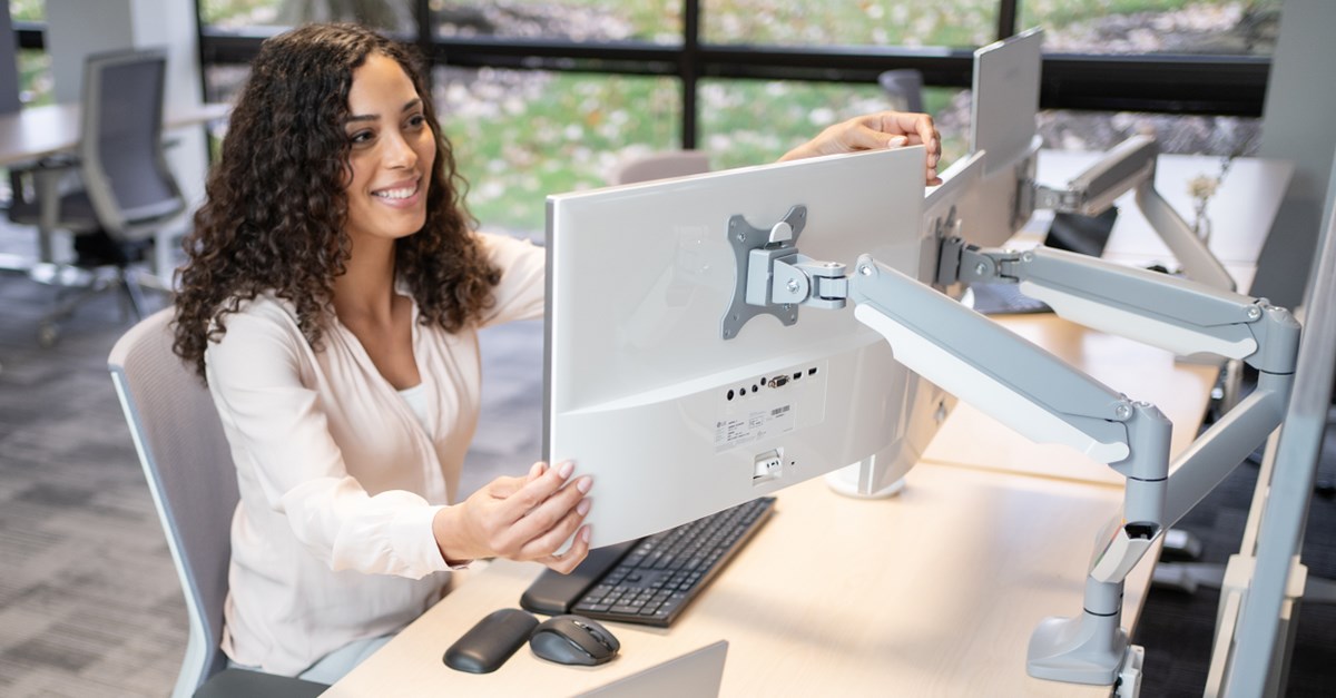 Woman using a Kensington monitor arm for two monitors