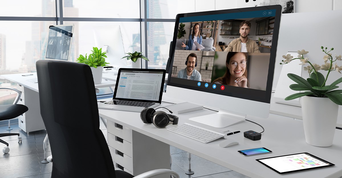 Desk with a tablet, desktop computer, laptop and a headset connected to the Kensington audio switch