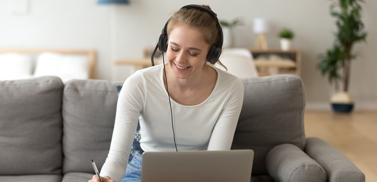 Woman in a video call smiling and using Kensington H1000 headset 