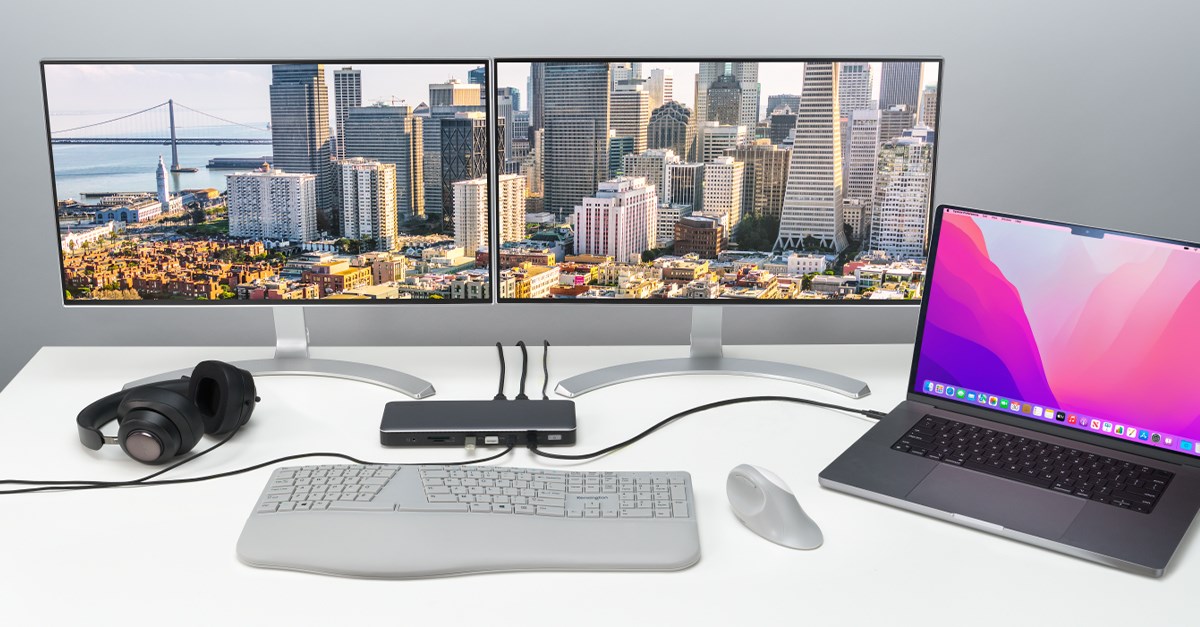 SD5760T docking station connected to a MacBook and monitor on a desk with a keyboard in front of it and a camera to the side. 