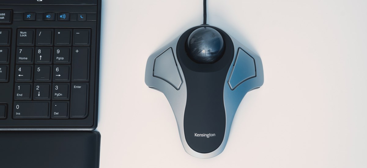 Close up to a Kensington Trackball on a white desk with a keyboard on the side .