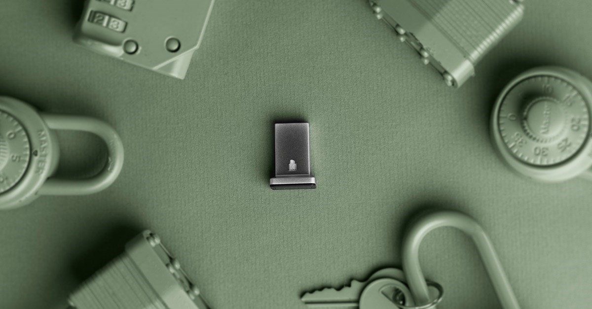 A Kensington VeriMark security key on a green background surrounded by locks.