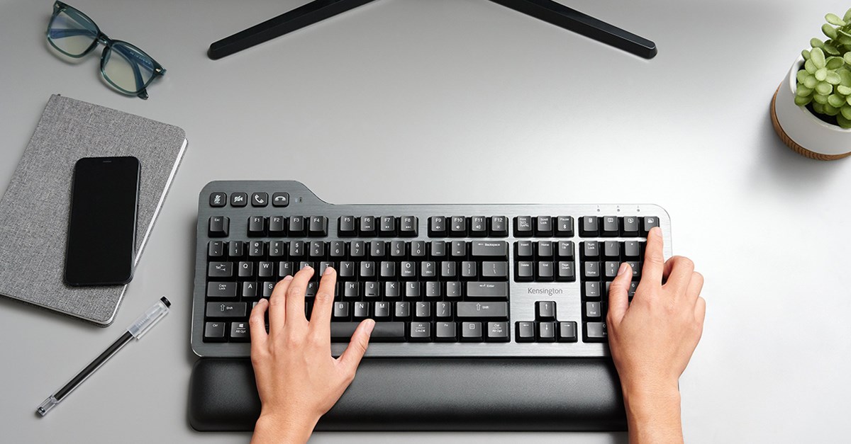 Kensington Mechanical Keyboard on a white desk and two hands typing on it. 
