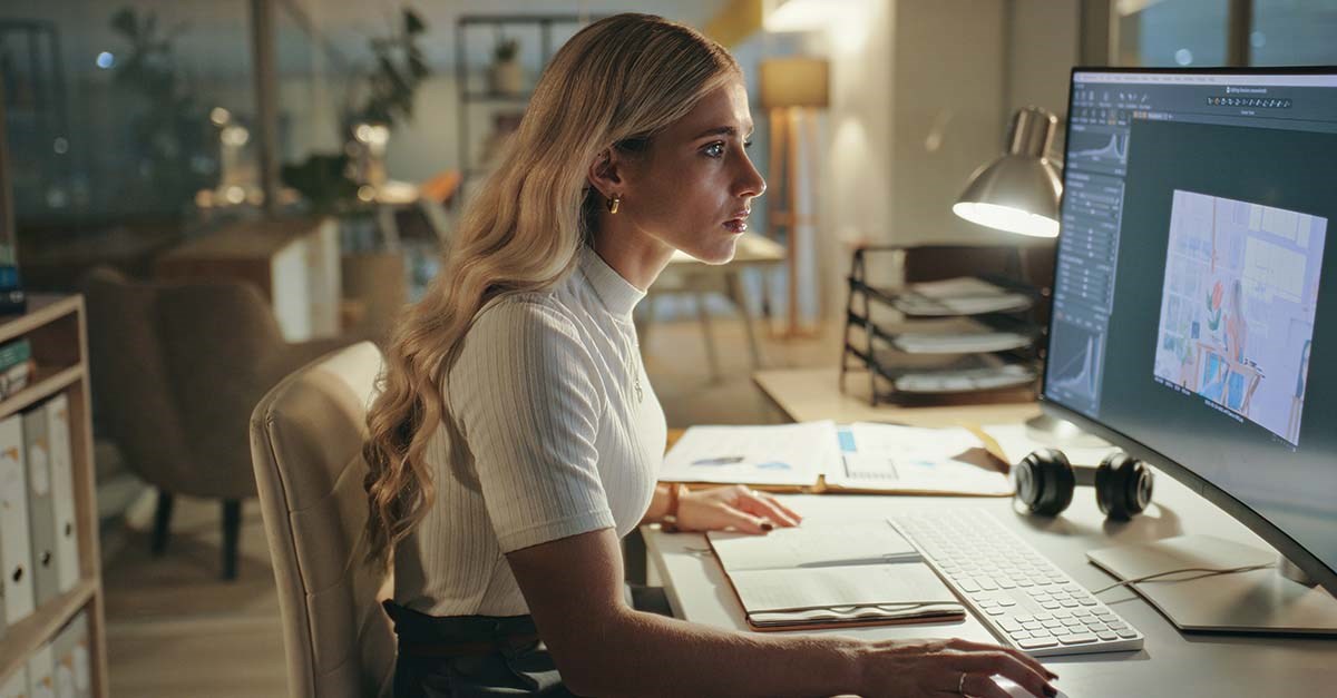 woman looking intently at a large computer screen.