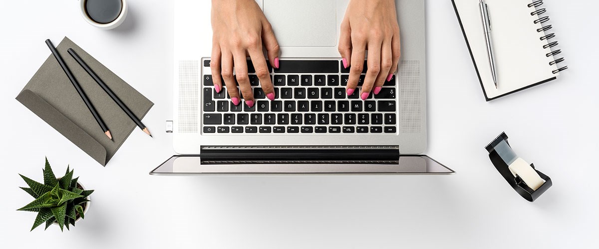 Woman typing on a laptop.