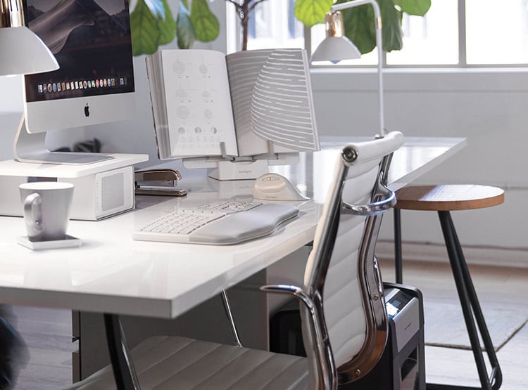 A kensington shredder placed next to the desk at a house office.