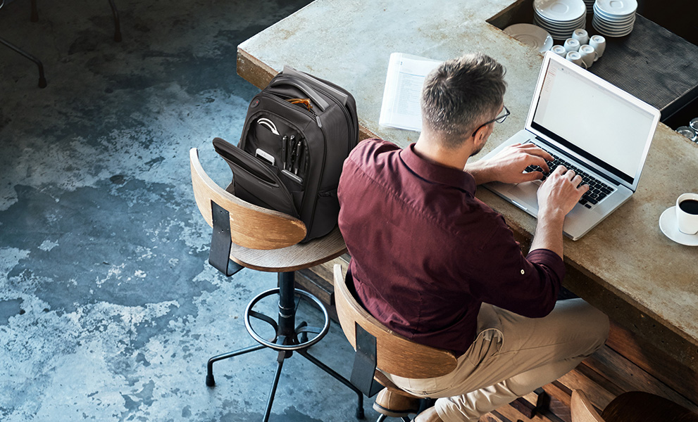 Man workin from a coffee shop using kensington products.