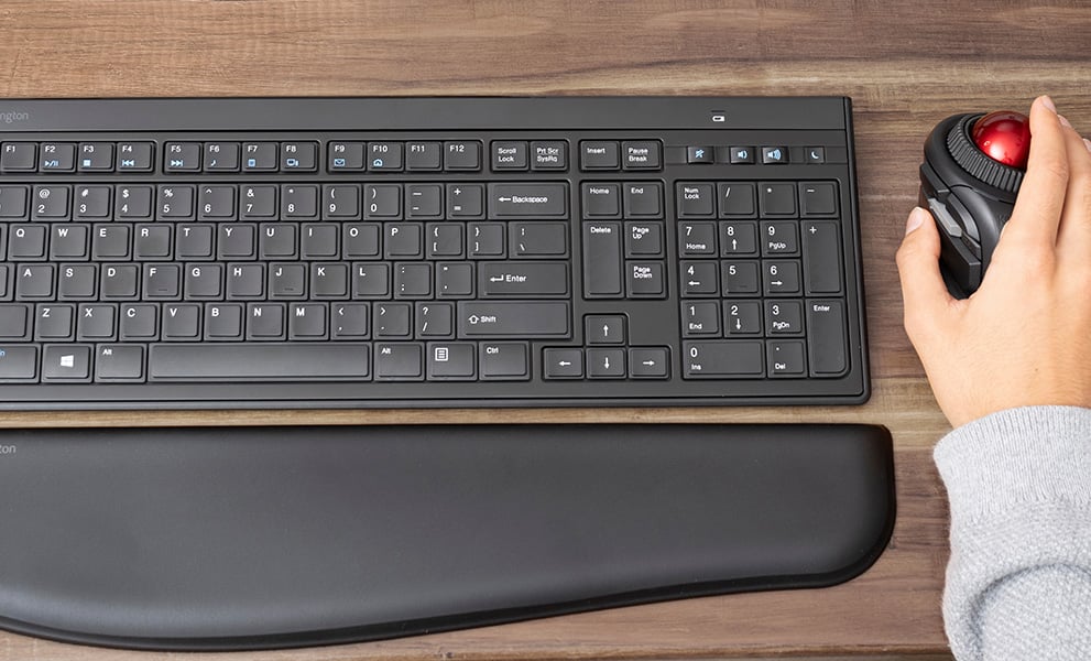 Kensington black keyboard, wrist riser for trackball and keyboard, and trackball on desk.