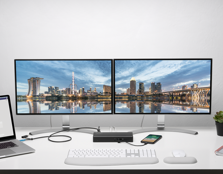 2 tech people working with multiple screens connected with a studio dock.