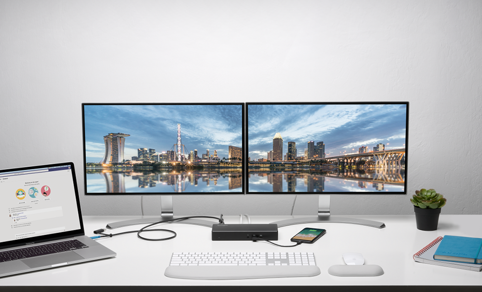 2 tech people working with multiple screens connected with a studio dock.