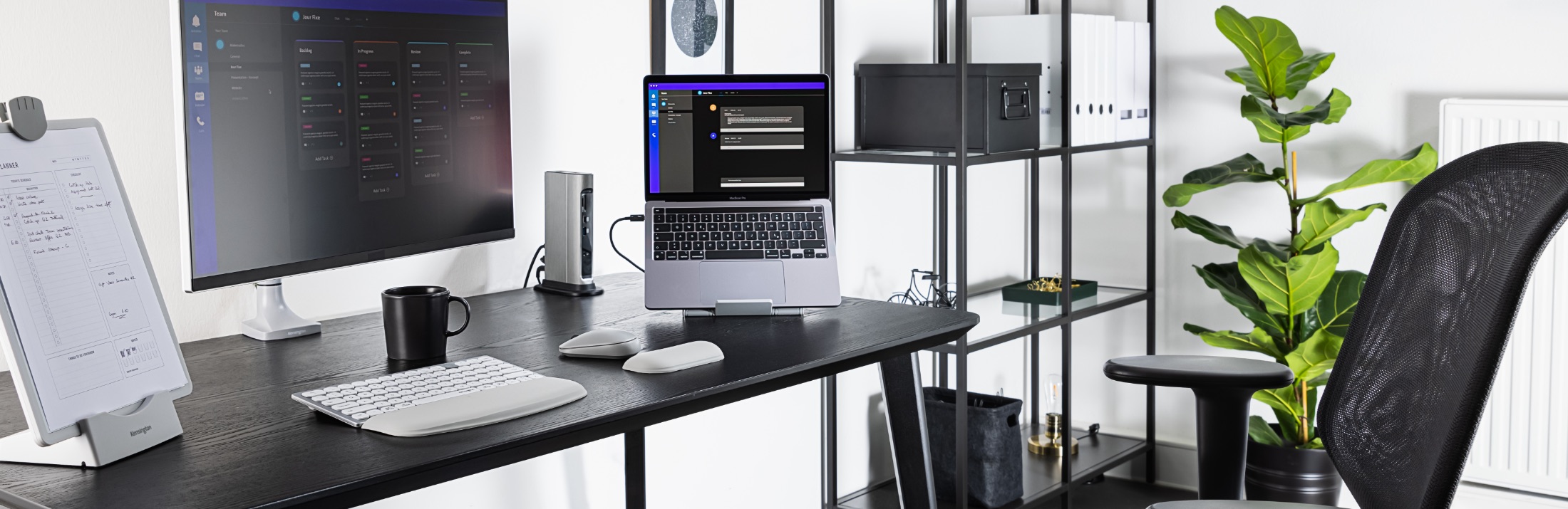 Desktop with Kensington wrist rest, keyboard, mouse, docking station, and laptop riser