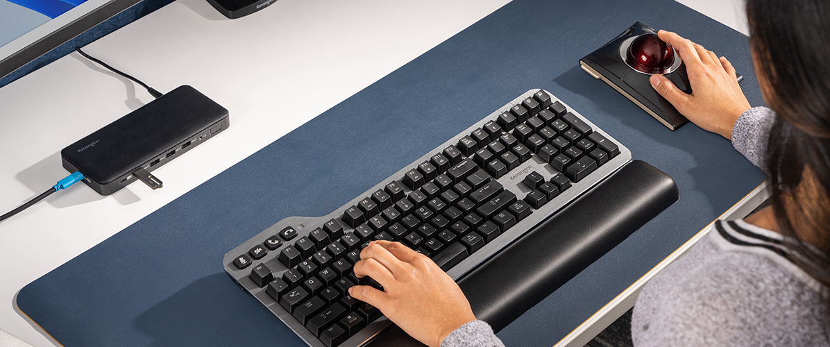 在桌面上使用 MK7500F QuietType Pro 机械键盘的女士。
