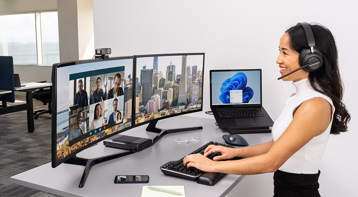 Woman in an office attending a virtual meeting using a Kenington H3000 headset