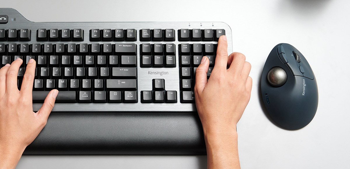 Pro Fit Ergo TB550 Kensington Trackball alongside a Mechanical Keyboard, on a grey desk.