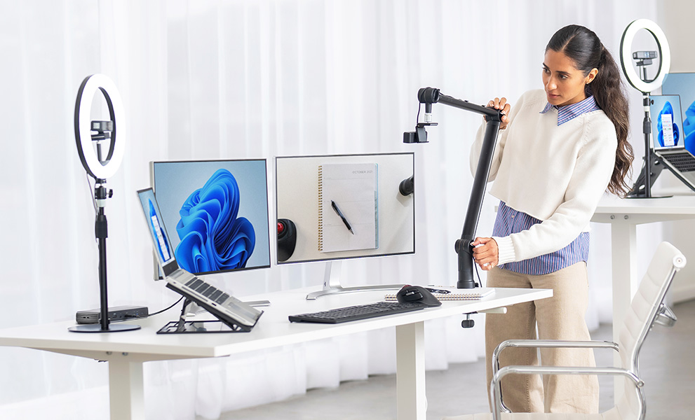 Woman setting up her desktop with Kensington Pro Video Conferencing products