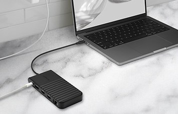 Laptop connected to a docking station on a marble surface.