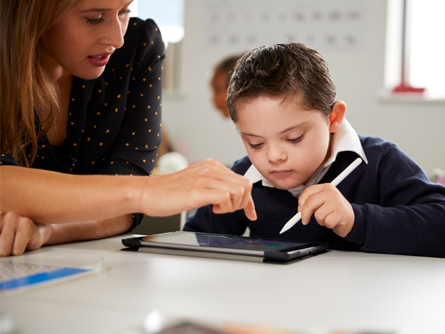 Teacher helping student at desk